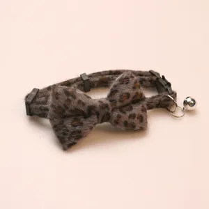 Plush leopard print pet collar with bow and bell, soft cat dog neck accessory detail shot
