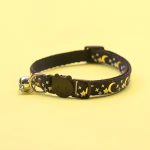 Close-up detail of cute pet collar with gold foil star moon print and cat face safety buckle.