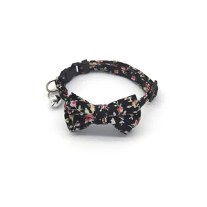 Floral cat collar featuring a cute bow and bell, soft fabric pet accessory close-up view.