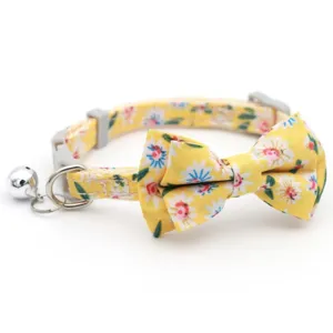 Yellow floral cat collar detail showing cute fabric bow tie, metal bell and safety buckle.