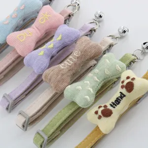 Detailed view of colorful cute cat and dog collars with embroidered bone pendants and bells.