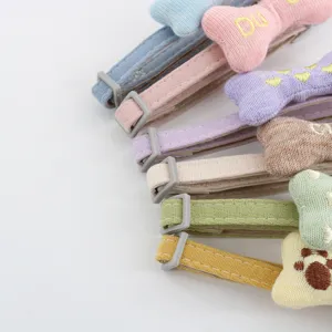Close-up of cute knitted stuffed bone pet collar detail with adjustable buckle and soft fabric.