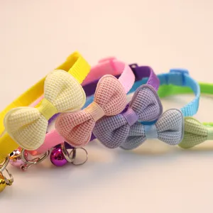 Close-up detail of colorful pet collars with cute bow knots and bells for small dogs cats.