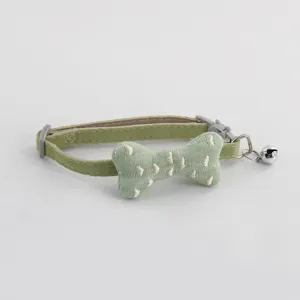 Green fabric pet collar with stuffed bone charm and bell for cats and dogs detail view