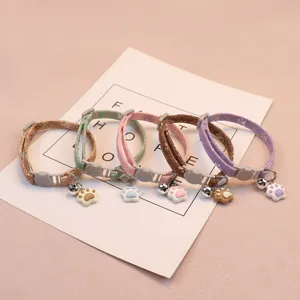 Detailed view of colorful pet cat collars with cute paw charms, bells and adjustable buckles.