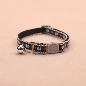 Detailed view of the floral pet collar showcasing the woven fabric and shiny bell.