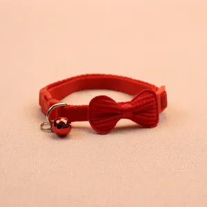 Red pet collar detail view featuring a cute bow and metallic bell for small cats and dogs.