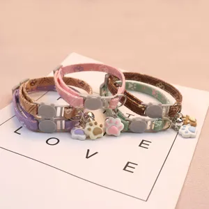 Adjustable pet cat dog collar with cute paw print charm and bell, soft fabric neck strap.