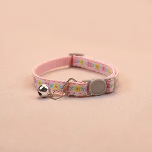Detailed view of a cute pink floral cat and dog collar with a safety buckle and small bell.