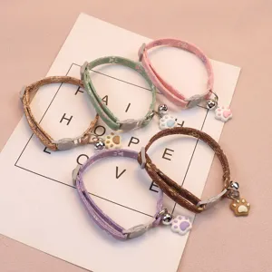 Adjustable pet collar with cute paw print charm and bell, perfect for cats and small dogs.