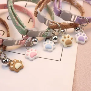 Adjustable cute pet cat collar with safety buckle, metal bell and lovely paw pendant accessory.