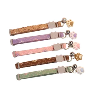 Cute adjustable pet cat collar with bell and silicone paw pendant, soft fabric neck strap.