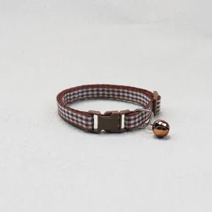 Brown checkered pet collar detail, soft fabric strap with durable plastic buckle and copper bell.