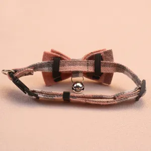 Vue rapprochée détaillée du collier pour chat à carreaux réglable avec nœud et cloche.