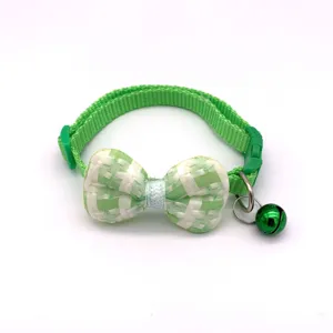 Detailed view of green plaid pet collar with cute bowknot and metal bell for cats and dogs.