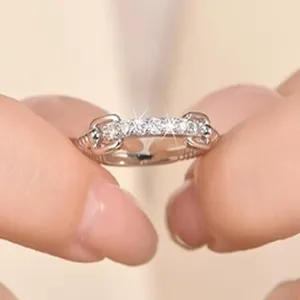 Gros plan détaillé de la bague fine en moissanite tissée, scintillant délicatement sous une lumière.