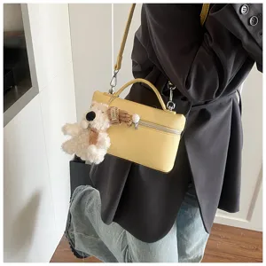 Vista dettagliata della borsa a mano gialla alla moda con un grazioso ciondolo in peluche.