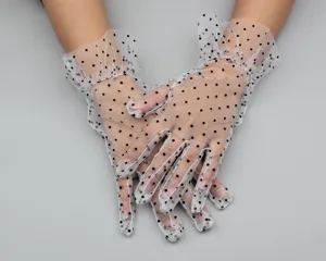 Close-up of white sheer mesh polka dot gloves with delicate ruffled cuffs, detail view.