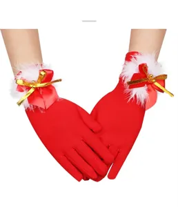 Close-up detail of red Christmas plush gloves with white fur trim and gold ribbon bows for holiday.