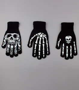 Detailed view of black knit Halloween skeleton gloves with white skull bone patterns.