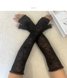 Vue de détail de gants longs en dentelle noire style gothique avec motif de toile d'araignée.