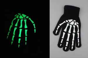 Close-up detail of glow-in-the-dark skeleton bone pattern on black knitted glove for night use.