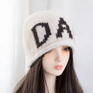 Primer plano detallado del acogedor gorro de punto con letras, textura suave y cálida de invierno.