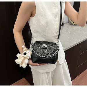 Elegante borsa a tracolla nera trapuntata con catena e grazioso ciondolo in peluche.