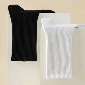 Detail view of black and white ribbed crew socks displayed neatly on white blocks.