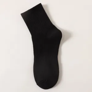Close-up detail shot of the black ribbed mid-tube sock, showing fine knitting and texture.