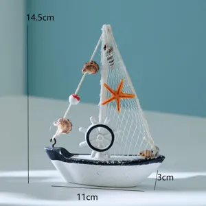 Detailansicht des maritimen Mini-Holz-Segelboot-Modells, mediterrane Tischdeko mit Muscheln.