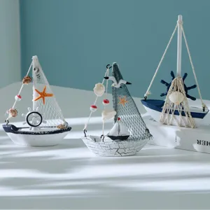 Detailansicht der maritimen Mini-Holz-Segelboot-Ornamente mit Muscheln und Fischnetzen.