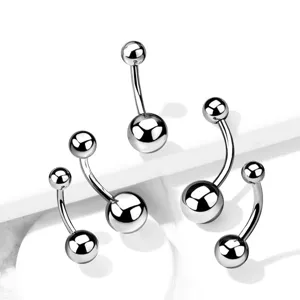 Close-up details of minimalist stainless steel belly rings, curved barbell piercing jewelry.