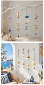 Mediterranean nautical wind chime detail featuring hanging sailboat and shell ornaments.