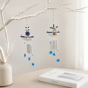Close up detail of Mediterranean style sailboat wind chime with blue stars and hanging metal tubes.