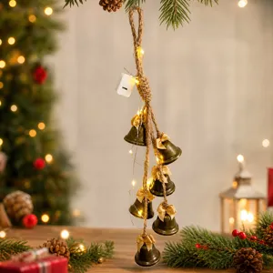 Detailed view of rustic Christmas bell hanging ornament with warm fairy lights and bows.