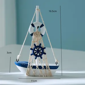 Detailed view of miniature wooden sailboat with blue white finish, net, and steering wheel.