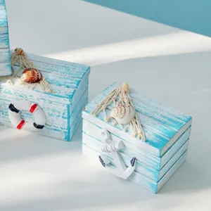Detalle de caja de madera estilo mediterraneo con ancla y concha decoracion playa.