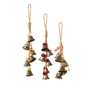 Hanging Christmas bell decorations with rustic jute rope and festive bows for holiday party.
