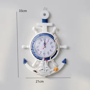 Detalle de bonito reloj de pared con ancla de madera estilo mediterráneo y un velero.