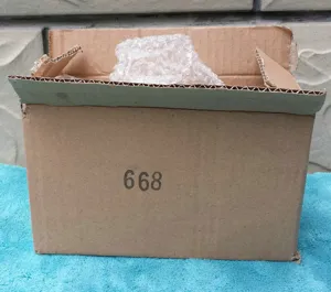 Cardboard packaging box with bubble wrap interior showing wooden ornament delivery box detail view.