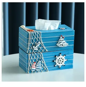 Dettaglio di una scatola di fazzoletti in legno in stile mediterraneo con decorazioni nautiche.