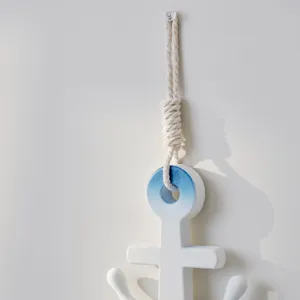 Detalle de decoración de pared de ancla de madera estilo mediterráneo, blanco y azul.