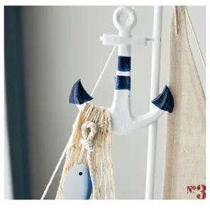 Primer plano de adorno de velero náutico, ancla de madera y vela de lona para decoración.