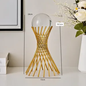 Detalle de adorno de bola de cristal con soporte de metal dorado y elegante decoración.