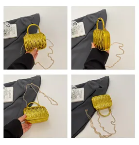 Shiny gold metallic matelasse mini box handbag with elegant chain crossbody strap style.