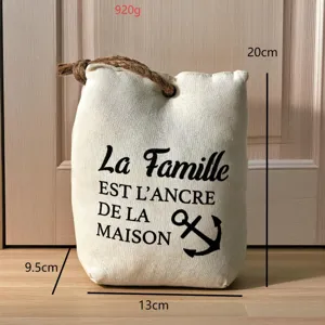 Dettaglio fermaporta in tela con testo francese, dimensioni e comodo riempimento di sabbia.