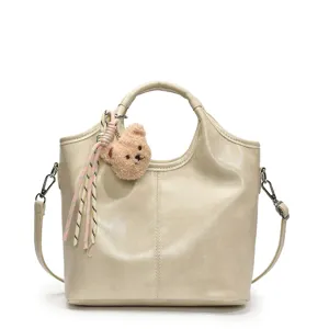 Elegante weiche Ledertasche mit süßem Bären-Anhänger und Schultergurt für den Alltag.