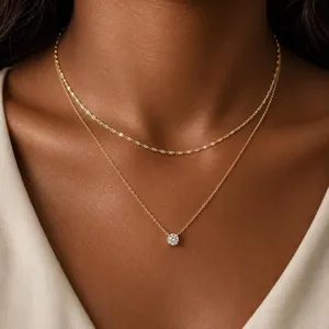 Élégante chaîne dorée double minimaliste avec pendentif solitaire étincelant pour femme.