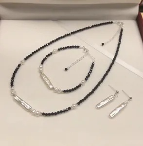Elegante conjunto de joyas con perlas barrocas negras que incluye collar pulsera y pendientes.